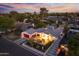 An elegant aerial shot reveals this property, complete with a red garage door, lush landscaping, and illuminated exterior at 3429 E Coolidge St, Phoenix, AZ 85018