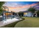 Expansive backyard featuring a sparkling pool, lounge area, and putting green for relaxation at 3429 E Coolidge St, Phoenix, AZ 85018