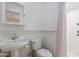 Cozy bathroom featuring a pedestal sink, toilet, shower with tile surround, and beadboard at 3429 E Coolidge St, Phoenix, AZ 85018