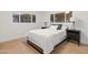 Cozy bedroom with hardwood floors, two windows, and black nightstands with lamps at 3429 E Coolidge St, Phoenix, AZ 85018