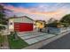 Beautiful home exterior with red garage door, modern driveway, and manicured front yard at sunset at 3429 E Coolidge St, Phoenix, AZ 85018