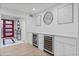Elegant wet bar boasts wine coolers and marble countertops near red modern front door at 3429 E Coolidge St, Phoenix, AZ 85018