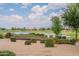 Serene backyard view of a pond and golf course with mature trees and landscaping at 36047 N Copper Hollow Way, Queen Creek, AZ 85140