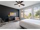 Inviting bedroom with a modern accent wall, chair, and large windows with scenic views of the community lake at 36047 N Copper Hollow Way, Queen Creek, AZ 85140