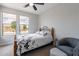 Bedroom with a ceiling fan, comfortable seating area, and great natural lighting from the large windows at 36047 N Copper Hollow Way, Queen Creek, AZ 85140