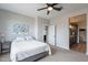 Bright bedroom featuring a ceiling fan, neutral walls, and a doorway to the bathroom at 36047 N Copper Hollow Way, Queen Creek, AZ 85140