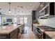 Modern kitchen with granite countertops, stainless appliances, and sleek cabinetry, open concept to living area at 36047 N Copper Hollow Way, Queen Creek, AZ 85140