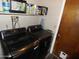 The laundry room features a modern black washer and dryer, shelf and ironing board at 3726 W Campo Bello Dr, Glendale, AZ 85308