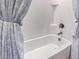 This bathroom features a tub/shower combination with white tile and a gray curtain at 41825 W Mesquite Rd, Maricopa, AZ 85138