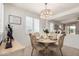 Charming dining room with decorative chandelier, round table and natural light from window at 41825 W Mesquite Rd, Maricopa, AZ 85138