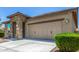 Beautiful home showcasing a stone-accented entrance, a two-car garage, and manicured landscaping at 41825 W Mesquite Rd, Maricopa, AZ 85138