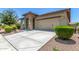 Attractive home showcasing a stone-accented entrance, a two-car garage, and manicured landscaping at 41825 W Mesquite Rd, Maricopa, AZ 85138