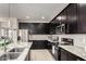 Modern kitchen features granite countertops, stainless appliances, and stylish dark cabinets at 41825 W Mesquite Rd, Maricopa, AZ 85138