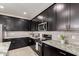 Modern kitchen features granite countertops, stainless appliances, and stylish dark cabinets at 41825 W Mesquite Rd, Maricopa, AZ 85138