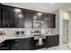 Modern kitchen features granite countertops, stainless appliances, and stylish dark cabinets at 41825 W Mesquite Rd, Maricopa, AZ 85138