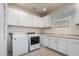 Bright laundry room features white cabinets and modern appliances for convenient chores at 41825 W Mesquite Rd, Maricopa, AZ 85138