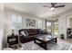 Spacious living room with a leather sofa, decorative rug, and natural light from the sliding glass doors at 41825 W Mesquite Rd, Maricopa, AZ 85138