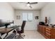 Bright home office with a large desk, rolling chair, neutral walls, and tile flooring at 41825 W Mesquite Rd, Maricopa, AZ 85138