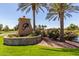Community signage with lush landscaping and mature palm trees in the background at 41825 W Mesquite Rd, Maricopa, AZ 85138