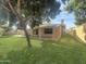 Landscaped backyard featuring a patio, spacious lawn and mature trees at 4533 W Cavalier Dr, Glendale, AZ 85301