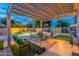 Evening view of the backyard featuring a covered patio, sparkling pool, and ambient landscape lighting at 490 W Encinas St, Gilbert, AZ 85233