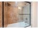 Clean bathroom with shower and tub combination, glass door, and tiled walls at 490 W Encinas St, Gilbert, AZ 85233