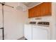 Bright laundry room featuring a modern washer and dryer, wooden cabinets, and laundry storage at 490 W Encinas St, Gilbert, AZ 85233