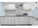 Updated kitchen showcasing granite countertops, white cabinets, and stainless steel appliances at 5011 S 20Th Pl, Phoenix, AZ 85040