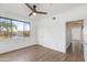 Bright bedroom features a ceiling fan, wood-look flooring, and a window with neighborhood views at 5401 E Van Buren St # 1004, Phoenix, AZ 85008
