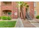 Apartment exterior with well-kept landscaping, stairs to upper units and a palm tree at 5401 E Van Buren St # 1004, Phoenix, AZ 85008