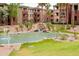 Community pond with a rock waterfall feature, lush landscaping, and a grassy area at 5401 E Van Buren St # 1004, Phoenix, AZ 85008