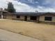 Single-story home featuring stone accents, desert landscaping, and modern solar panels on the roof at 5542 W Monte Cristo Ave, Glendale, AZ 85306