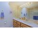 Bathroom featuring a double sink vanity, bright lighting, and a large mirror at 629 E State Ave, Phoenix, AZ 85020