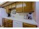 View of the kitchen with oak cabinets, white tile countertops and a double basin sink at 629 E State Ave, Phoenix, AZ 85020