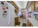 Full shot of the kitchen with white appliances and oak cabinets at 629 E State Ave, Phoenix, AZ 85020