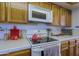 Close up shot of the white tile counter, white appliances, and oak cabinets at 629 E State Ave, Phoenix, AZ 85020