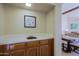 A sink with wooden cabinets and tile countertop with a view to dining area at 629 E State Ave, Phoenix, AZ 85020