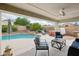 Inviting covered patio area with comfortable seating, fan, overlooking pool and spa at 6439 W Kristal Way, Glendale, AZ 85308