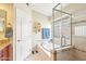 Bright bathroom features a soaking tub with tile surround and glass enclosed shower at 6439 W Kristal Way, Glendale, AZ 85308