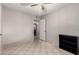 Open bedroom area featuring tile floors, a ceiling fan, and view into hallway at 6837 W Camelback Rd, Phoenix, AZ 85033