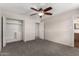 Spacious bedroom featuring carpet floors, a ceiling fan, and an open closet space at 6837 W Camelback Rd, Phoenix, AZ 85033