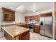 Well-appointed kitchen with dark wood cabinets, granite countertops, and modern appliances at 6837 W Camelback Rd, Phoenix, AZ 85033