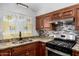Updated kitchen with stainless steel appliances, dark wood cabinetry, and stylish tile backsplash at 6837 W Camelback Rd, Phoenix, AZ 85033
