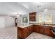 Stylish kitchen featuring dark wood cabinets, granite countertops, and a center island at 6837 W Camelback Rd, Phoenix, AZ 85033
