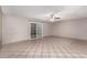 A bright living room with tile flooring, ceiling fan, and sliding glass doors at 6837 W Camelback Rd, Phoenix, AZ 85033
