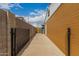 Long walkway with a block wall providing access to backyard at 6837 W Camelback Rd, Phoenix, AZ 85033