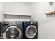 Modern laundry room with front loading gray washer and blue dryer, plus white shelf at 6900 E Princess Dr # 2247, Phoenix, AZ 85054