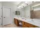 Bright bathroom with double sinks, tile floor, a large mirror, and white doors providing ample space at 726 E Heather Dr, San Tan Valley, AZ 85140
