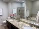 Bathroom featuring double sinks, granite countertops, and a large mirror, exuding elegance and functionality at 7272 E Gainey Ranch Rd # 122, Scottsdale, AZ 85258