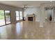 Bright living room with neutral tile flooring, a cozy fireplace, and access to an outdoor patio at 7272 E Gainey Ranch Rd # 122, Scottsdale, AZ 85258